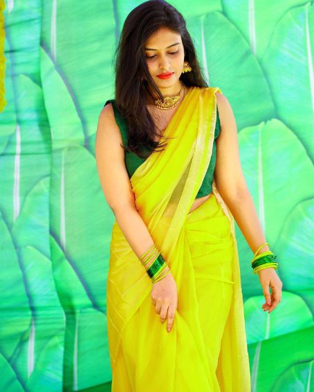 Yellow Saree With Bottle Green Sleeveless Blouse